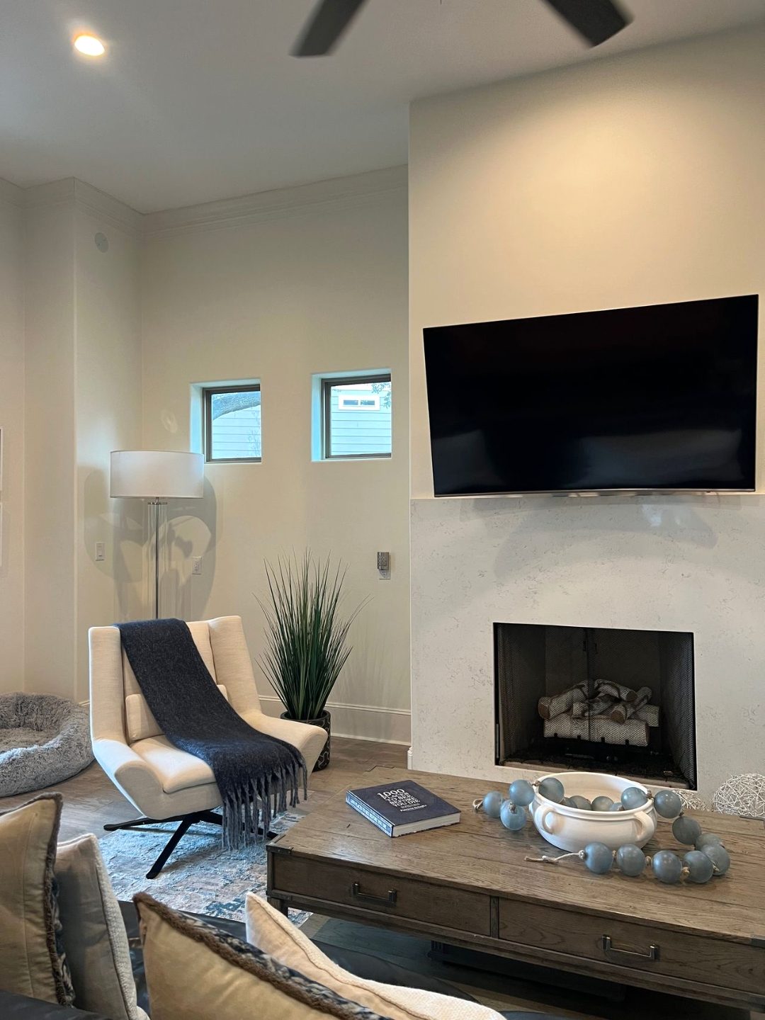 Living room built-in with stone fireplace surround and mounted television