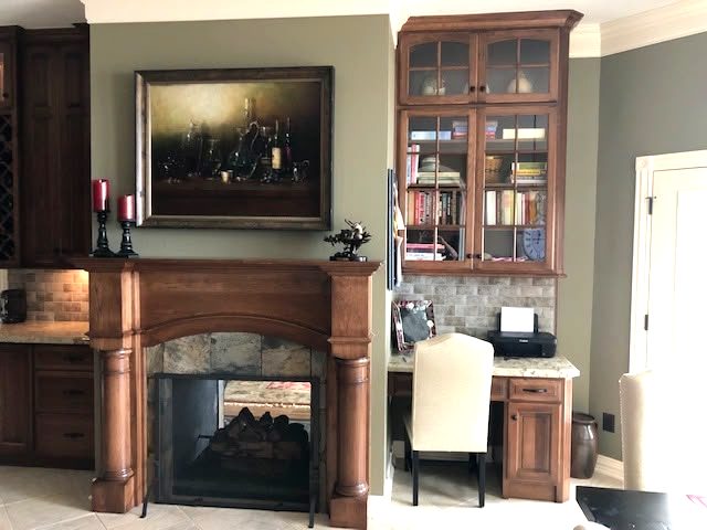Custom home study with granite-top desk, glass-front bookcase uppers and built-in wine storage