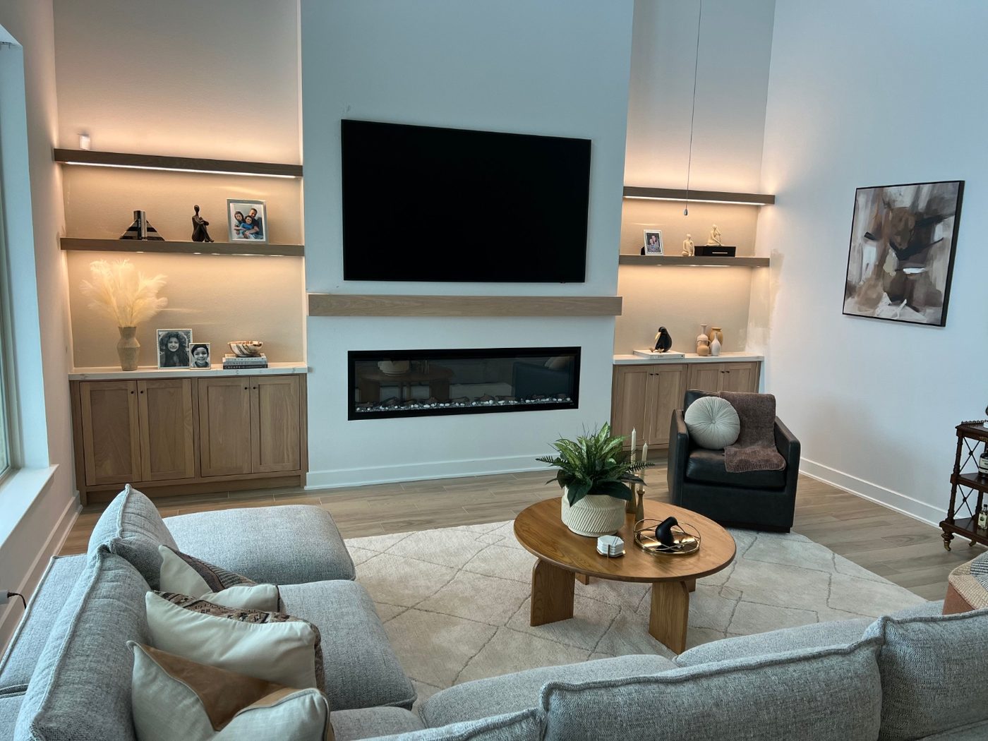 Custom entertainment center built-ins with floating shelves and linear fireplace