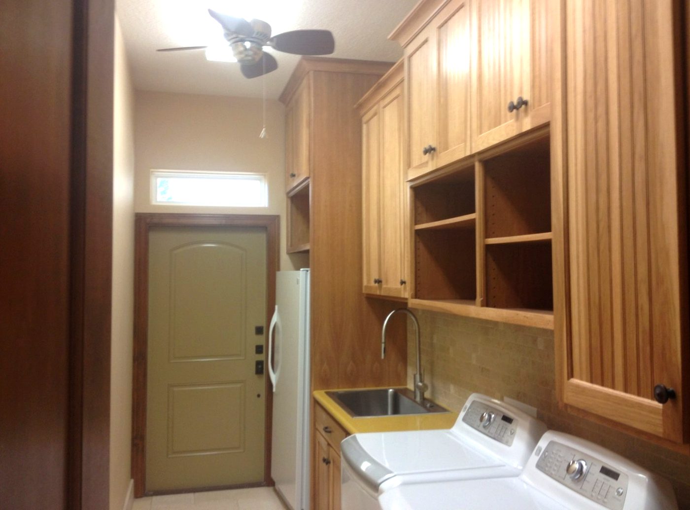 Custom mudroom and entry cabinets with open cubby shelving beside the back door