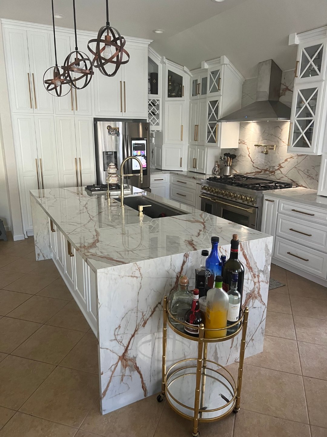 Custom wet bar and beverage cabinetry with marble waterfall island