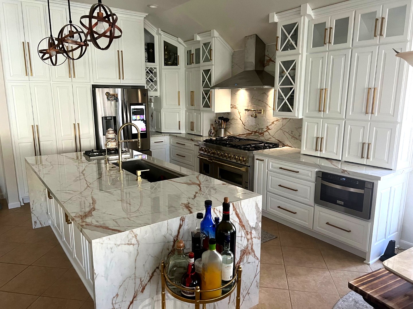 White kitchen with green marble island and custom hood